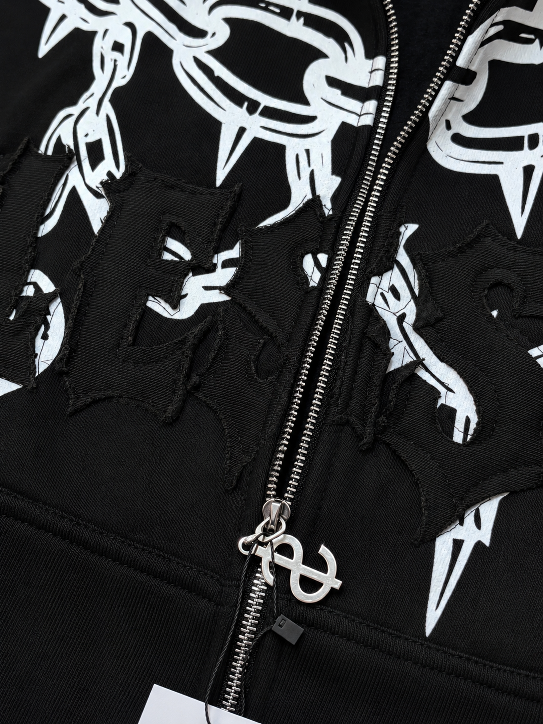 Black hoodie with white graphic designs on a black background