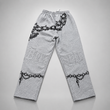 Gray sweatpants with black chain and lock designs on a light gray background