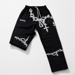 Black pants with white designs and 'KANGA' branding on a light gray background