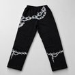 Black pants with white chain and barbed wire designs on a light gray background