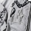 Gray sweatshirt with black chain and heart designs on a white background